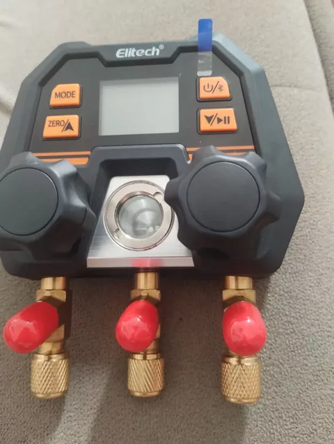 Manifold digital Elitech para medição de pressão em sistema de ar-condicionado, com botões laranja e portas de latão com tampas vermelhas