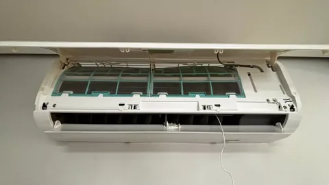 Evaporadora split branca com painel frontal e aletas abertos expondo filtros e turbina durante manutenção ou limpeza técnica