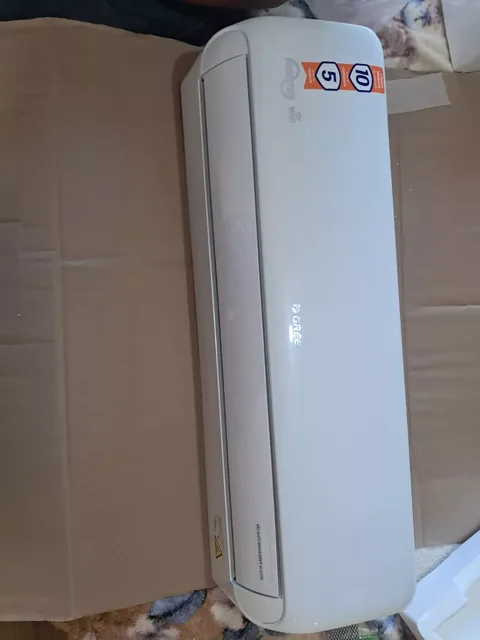 Evaporadora split Gree Inverter Wi-Fi nova sobre papelão, com selos de garantia e aviso para não ajustar manualmente as aletas